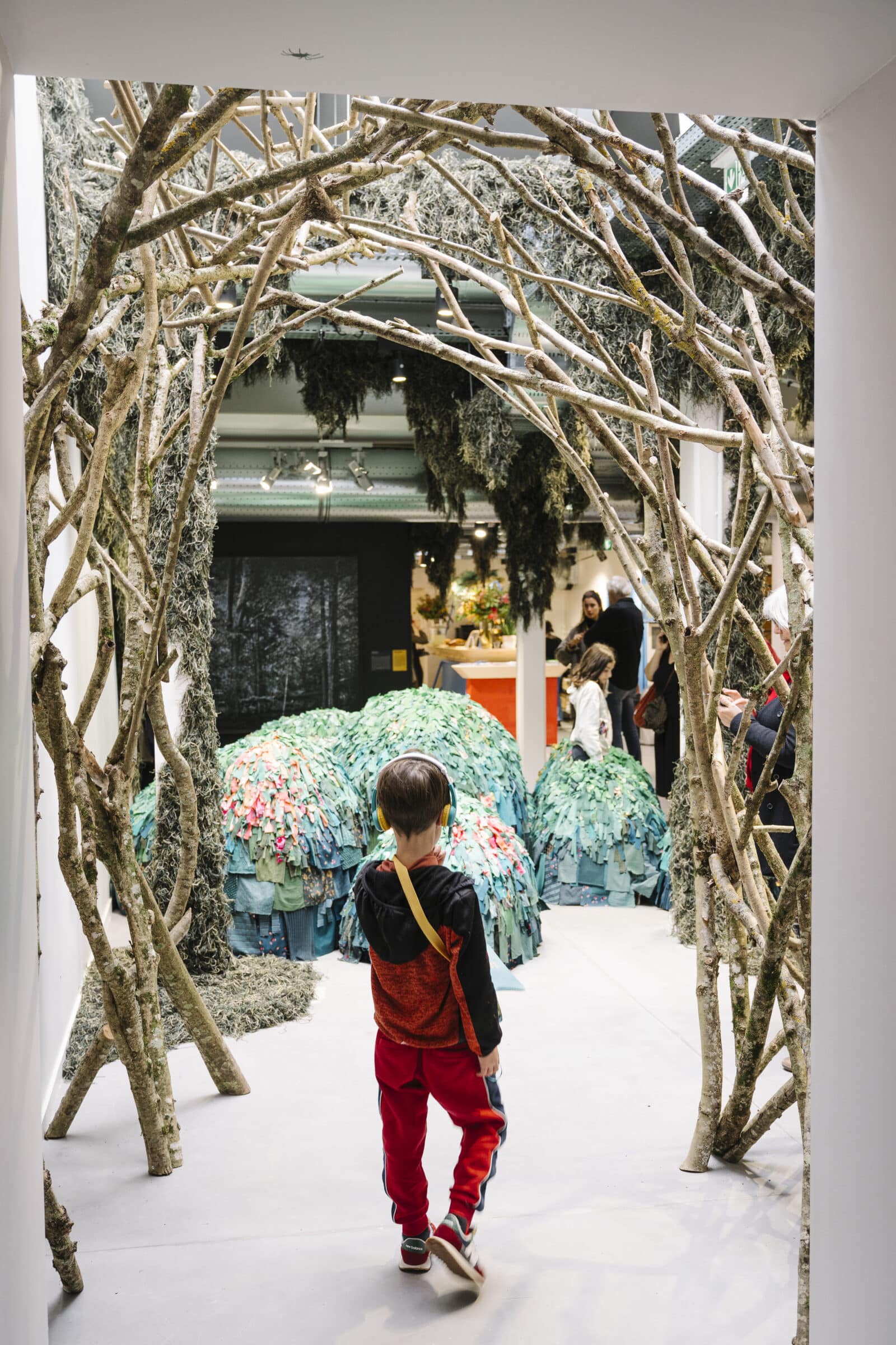 Enfant dans l'exposition Le Chant des Forêts avec sa boîte à histoires Lunii