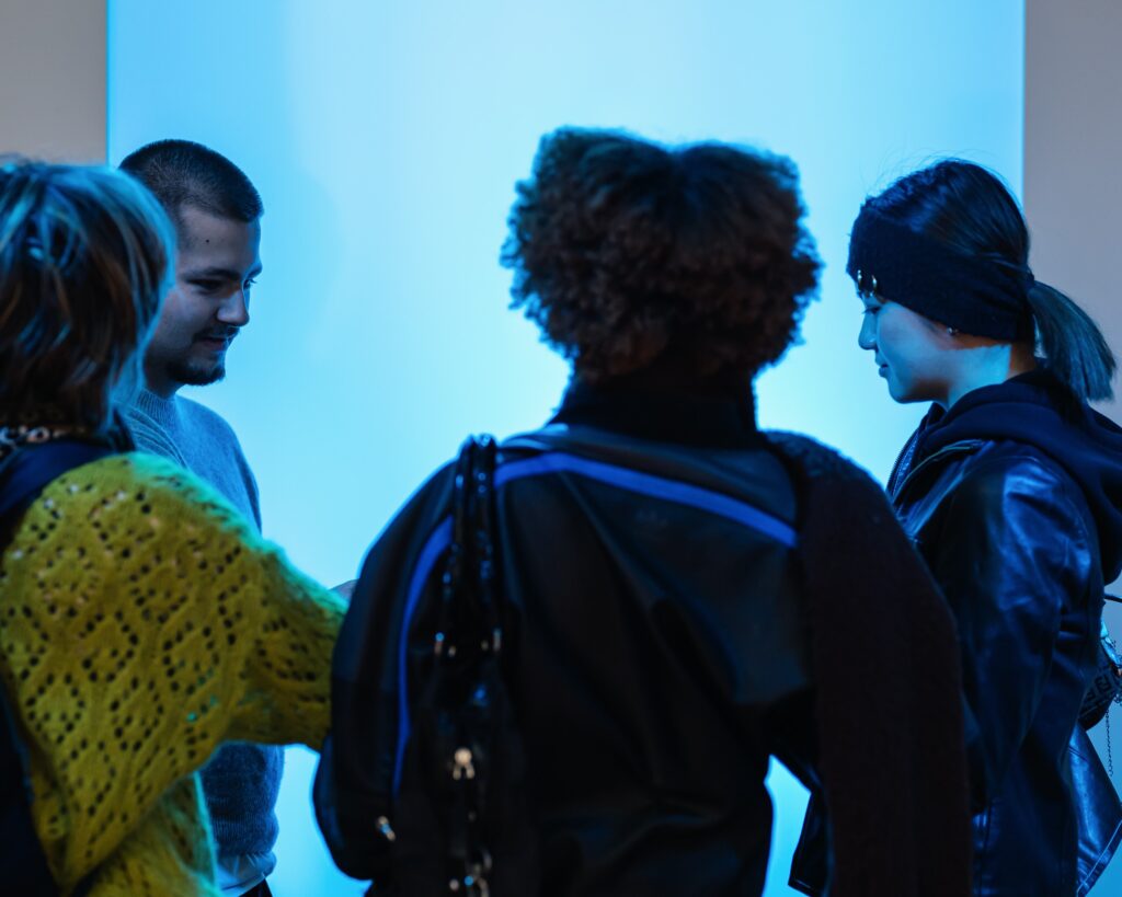 Quatre jeunes adultes essayant l'oeuvre "Lights contacts" de l'artiste Scenocosme dans le cadre de l'exposition Faisons corps du MAIF Social Club