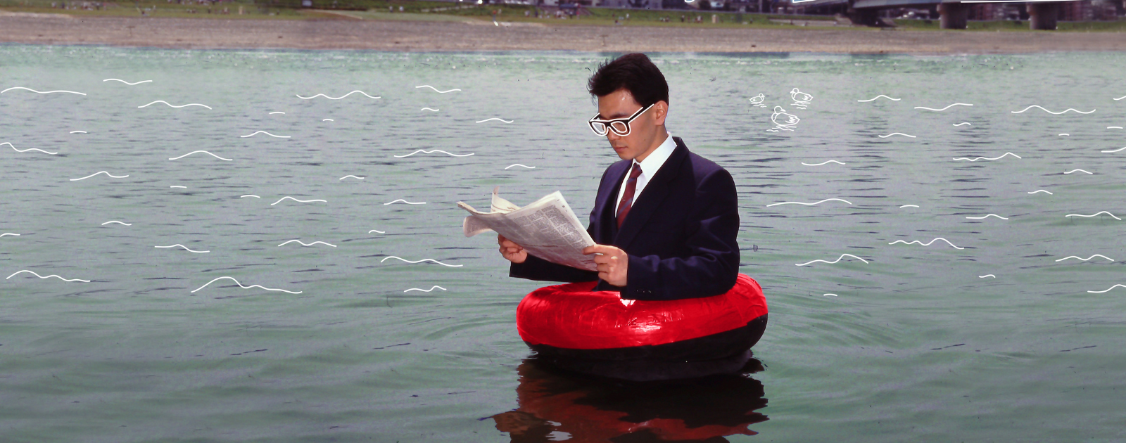 homme avec une bouée rouge sur l'eau qui lit le journal
